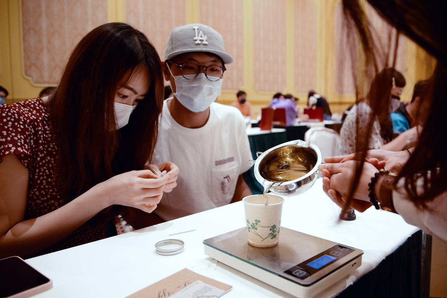 Pour melt wax on a cup with weight measurement in a candle workshop in Disneyland of The Hubble Studio.